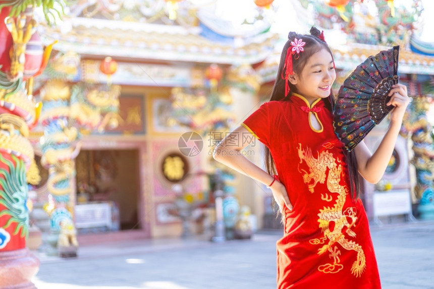 泰国身着中传统红宗山长相装饰的可爱亚洲小女孩在华神庙举办新年庆典风光盛会中文并举办扇子漂亮的图片