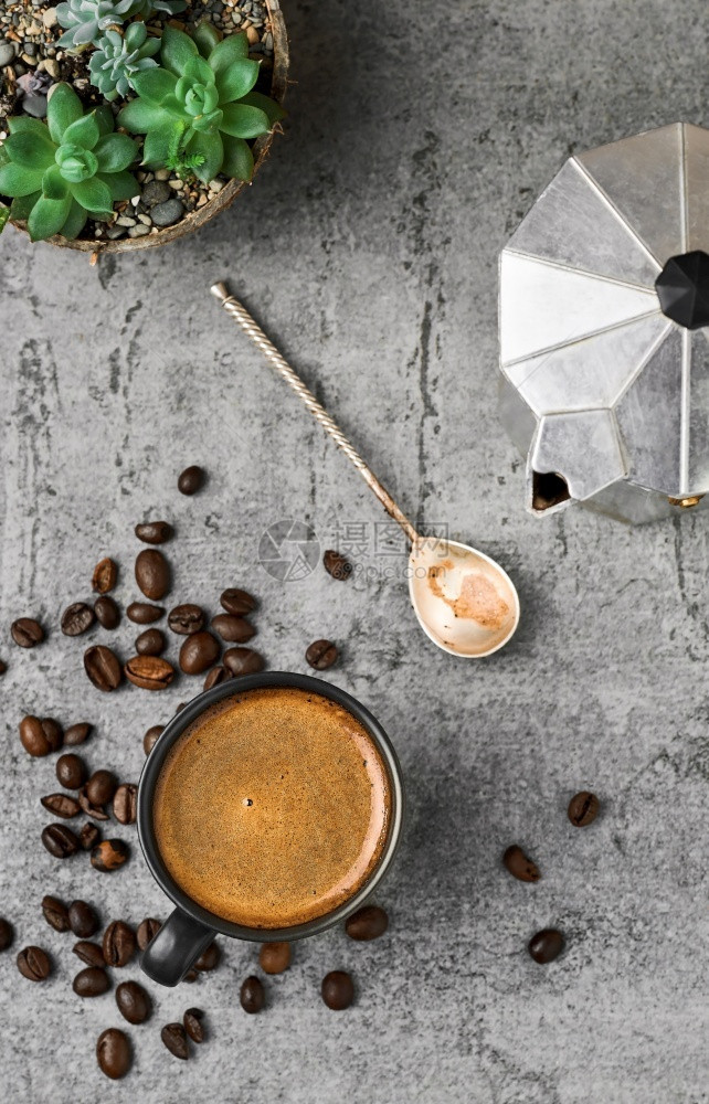 洒光滑的黑杯咖啡壶和豆在灰色石桌的头上风景咖啡或早餐休息动机图片