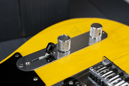 颜色捡起黄的收紧音调和量控制器以及经典黄色和黑电吉他手的开关背景图片