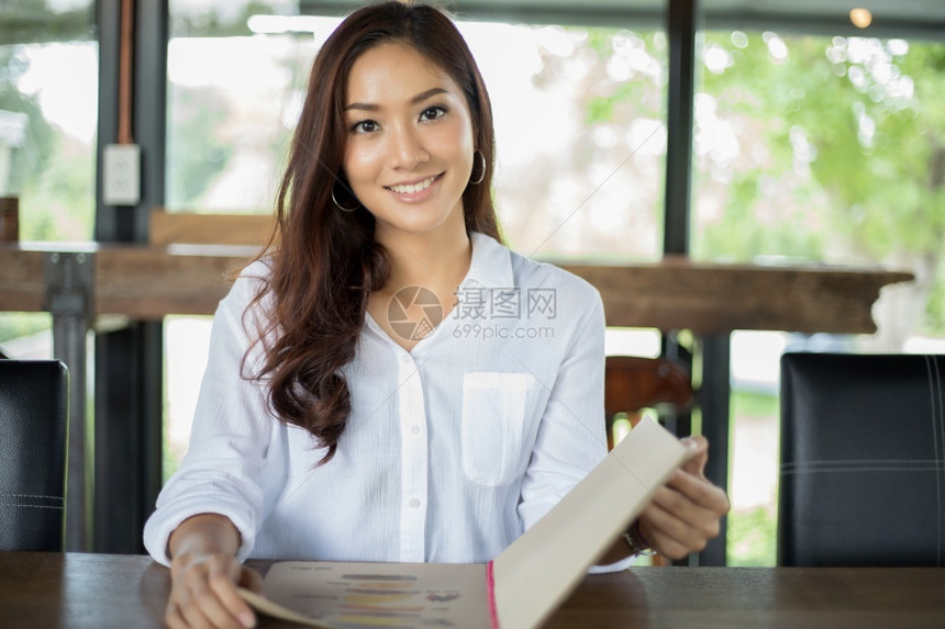 女孩保持服务员亚洲开放菜单在咖啡厅和餐点菜并微笑快乐时光图片