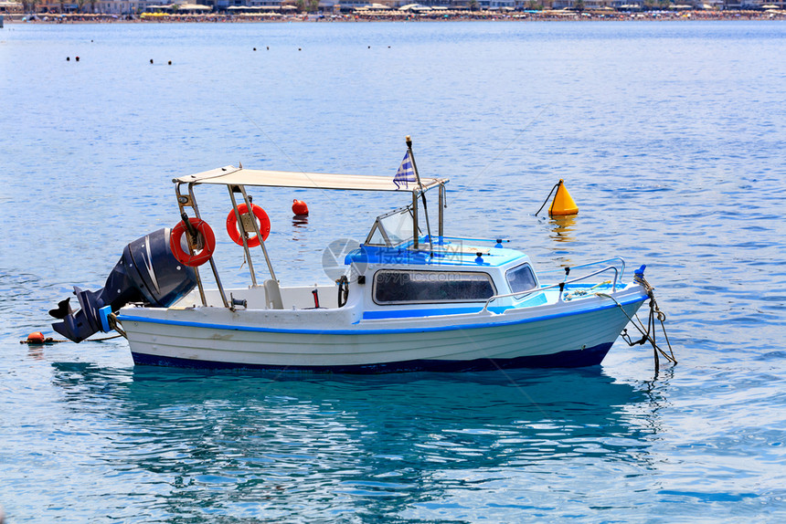 一艘带有强大马达和橙色救生圈的小型援船在希腊海岸的浪中摇摆以滩岸线为背景图像与复制空间海滩背景上一艘带有强大马达的小型救援船视图图片