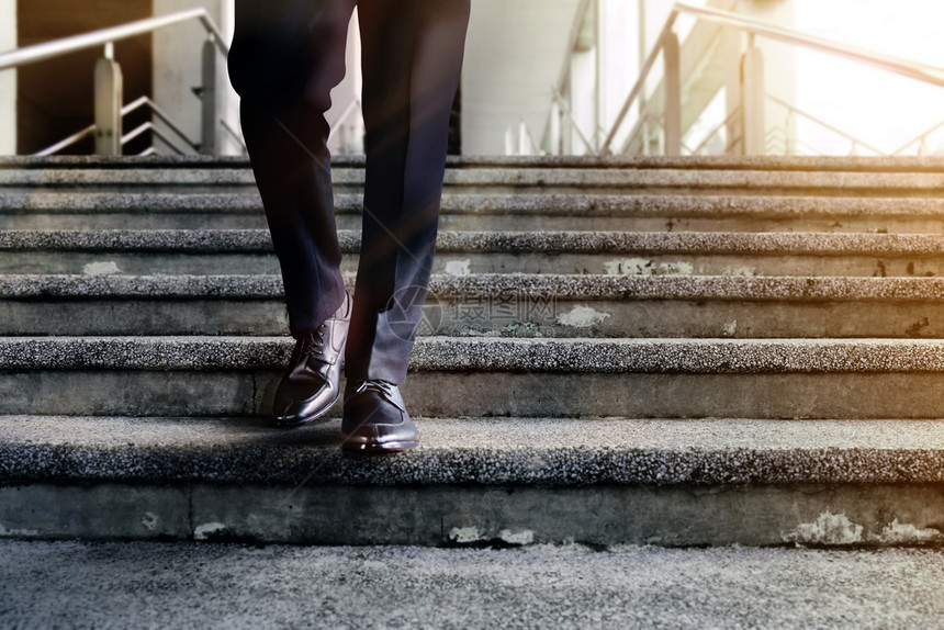 动力和具有挑战职业概念步骤成为功的低层商人在穿黑色正规服装的男子楼梯上行走中取得成功的一小段未来管理步行图片