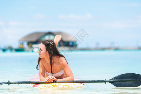 泳衣美女趴在浆板上休息冲浪板高清图片素材