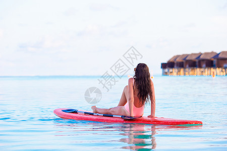 泳衣美女坐在浆板上享受阳光比基尼高清图片素材
