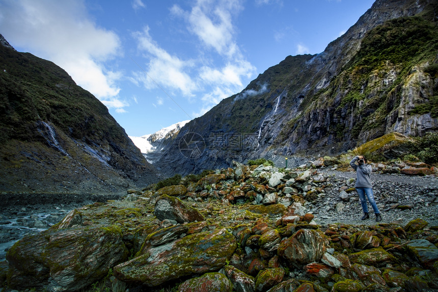 摄影记者拍一张照片在franzJosef冰川最受欢迎的旅游目地之一在西海岸南新泽游客岩石摄影师图片
