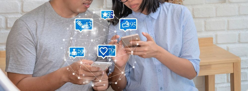 聪明的在现代咖啡店或工作场所使用智能手机为社交网路媒体使用包括类似爱评论人和fovotorite图标社交网络概念等数目的Likl图片