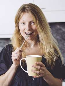 萨姆纳斯容光焕发一位美丽的金女在厨房里盛着一杯咖啡的照片眼睛可爱的高清图片素材