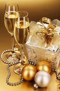斯塔克闪发光的弓长笛香槟和圣诞礼物两杯香槟圣诞礼物和球设计图片