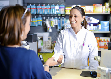 成人服务零售女药剂师工作人员就现代药店使用情况向客户提供咨询图片
