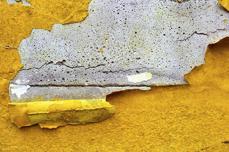 石膏材料破碎的混凝土墙有黄色橙剥皮涂漆旧破碎损坏的粗糙亮光背景纹理图片