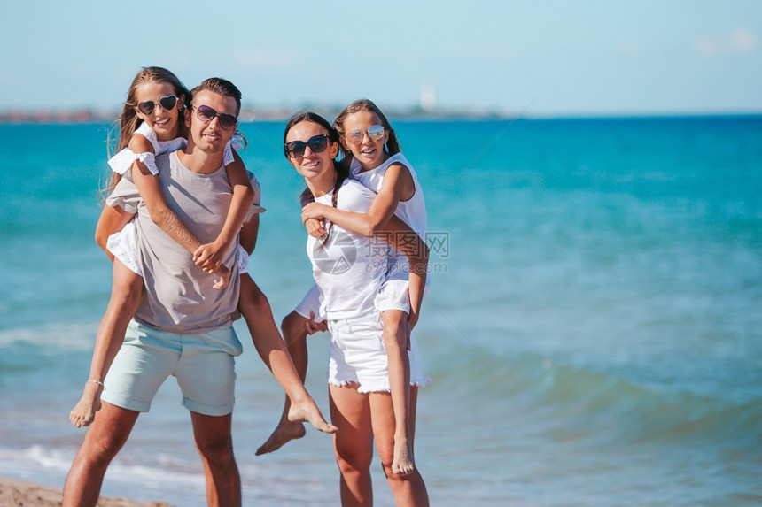 绿松石热带异国情调有两个孩子的父母在海滩上玩得开心度假的年轻家庭有很多乐子图片
