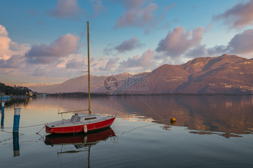 旅行游艇日落时分在阿尔卑斯山壮丽的湖上色彩缤纷的红船意大利伦巴第区洛韦雷市的伊塞奥湖全景奢华图片