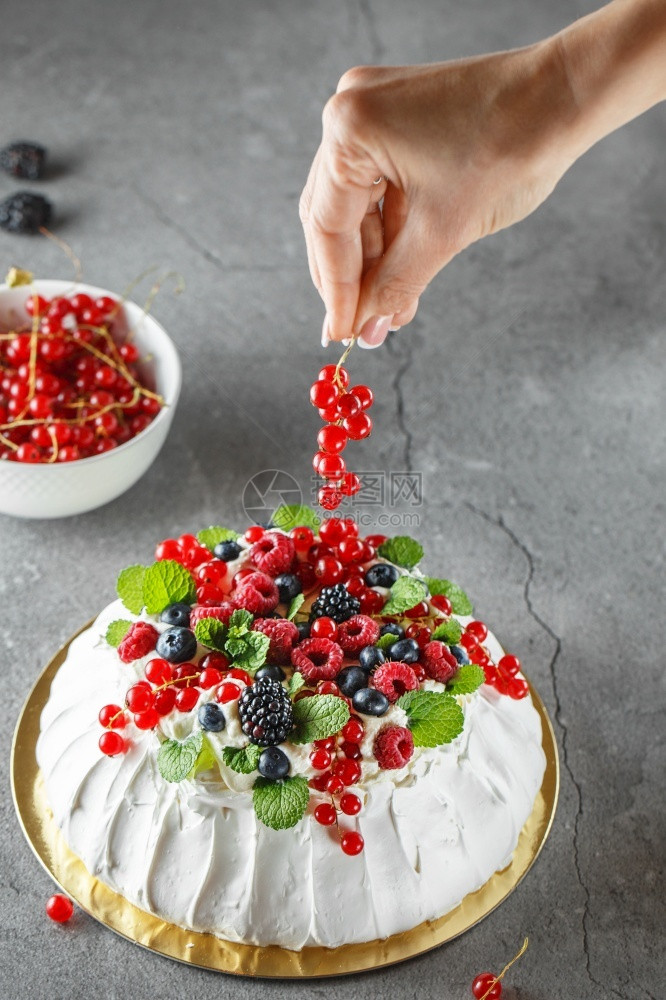 玫瑰Pavlova蛋糕加奶油和新鲜的夏天莓子关闭Pavlova甜点配有森林水果和薄荷食品摄影将蛋糕装饰过程用红卷饼果在照片上甜的图片