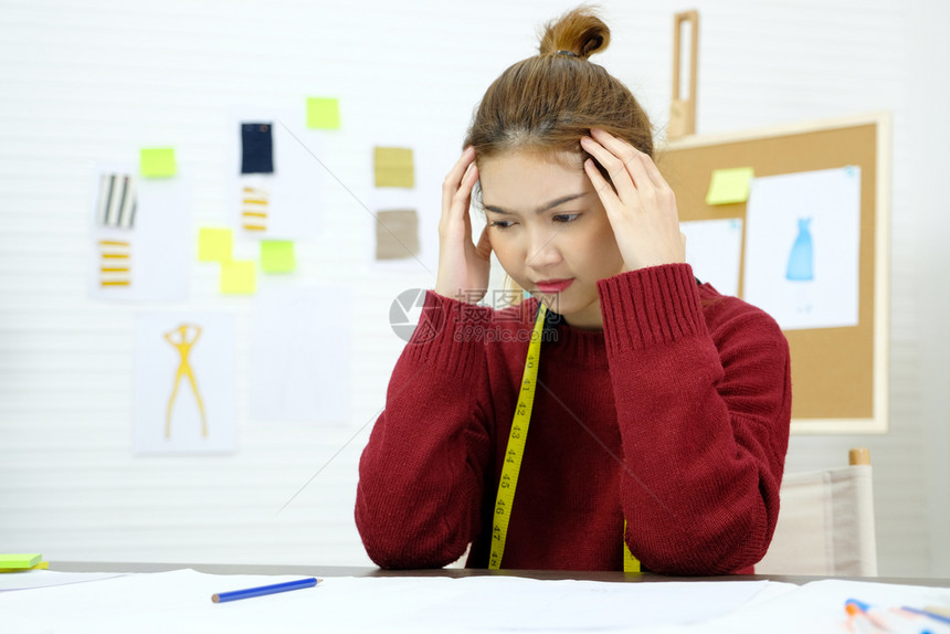失败在时装设计工作室办公桌人们的情感和办公室生活方式工作时有沮丧言论的年轻青女亚洲绝望不开心图片