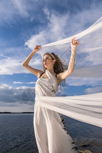 时尚漂亮的投标青春美丽年轻女人肖像手握着挥舞的织布在风中图片