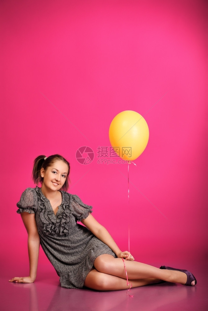 可爱的女孩拿着粉红背景的气球美丽华超过图片