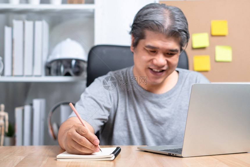 数字的在计算机上工作的笑亚洲商人注意到笔记本上的在家工作直到CoronaCOVID19隔离快乐自由职业者工作生活方式的概念高兴地图片