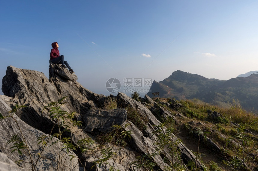 徒步旅行美丽的爬坡道女游客坐在岩石的最顶端在日落时景色优美的DoiPhaTang旅游点Sunset景点清Rairsqopos隐藏图片