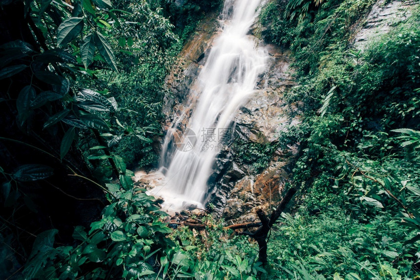 自然公园中流水的软雨林中美丽的瀑布岩石泰国东盟图片