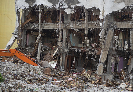 挖掘因爆炸而毁坏的建筑工业废弃混凝土建筑废墟和碎的地震破坏飓风灾害损或倒塌的建筑被弃置水泥建筑损害瓦砾背景图片