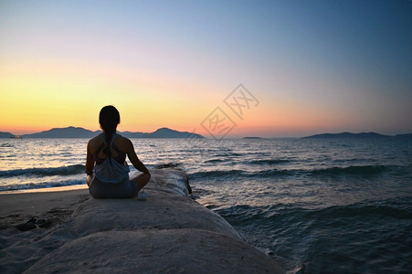 练习摆姿势红色的妇女冥想日落时在海滩的边放松瑜伽健康和SPA的概念平衡高清图片素材