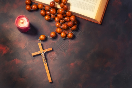宗教的与红蜡烛和圣经书精神氛围宗教概念交叉的大木罗萨里珠子和祈祷木头图片