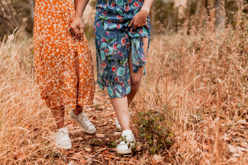 女孩两个年轻者穿着长裙在树林里走落下成人图片