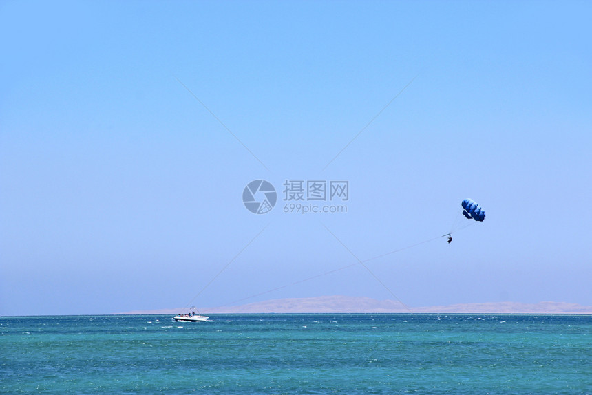 旅游的假期人喜欢在埃及红海热带度假胜地滑翔伞人们在埃及度假胜地休息旅游概念暑假在船后面的降落伞上飞行人喜欢在埃及红海热带度假胜地图片