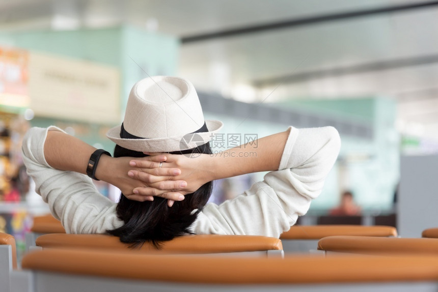 观赏亚洲旅行者在机场度假单人旅行夏天和节假日无护身女游客戴帽子在休息室举起手来放松头部的风景旅游者戴着帽子畅快坐到达图片