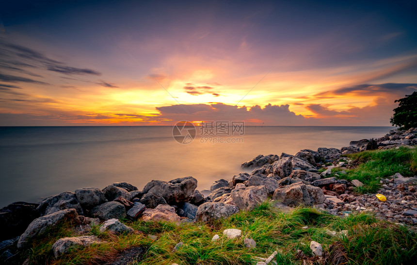 海洋阳光日落时在石滩上的岩美丽海边夕阳天紫光海与空黄昏时的热带海风云平静和放松生命自然景观清奎尔和平的概念夏天图片