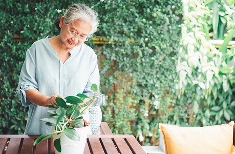 一位快乐和微笑的亚洲老年妇女在退休后家里安放业余爱好为老年人创造幸福生活方式和良好健康的概念对年长者来说外部春天为了背景图片