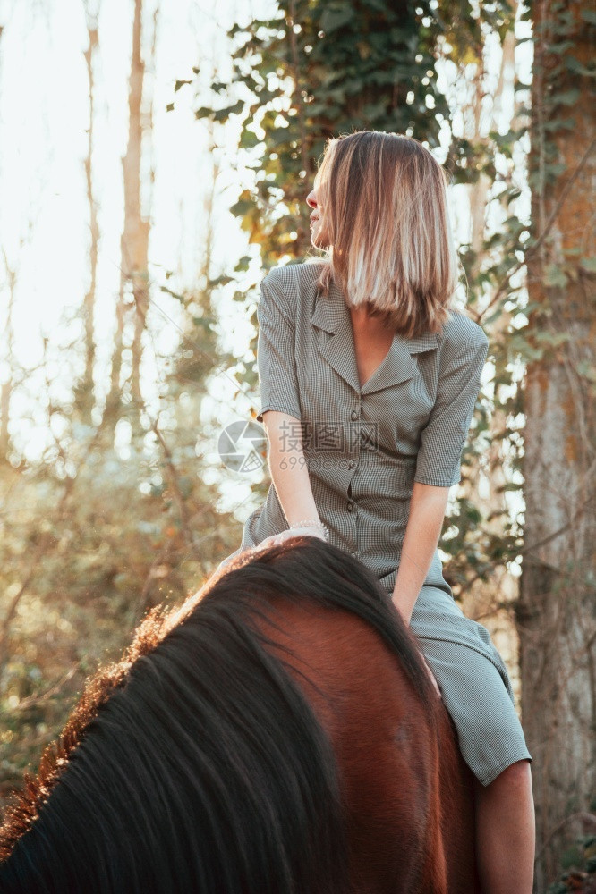 肖像牧场幸福美丽的年轻女子骑着她的棕色马穿着衣服图片