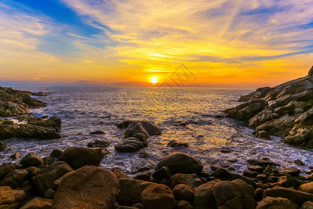 水灯岩石海岸的红日落多岩石夏天图片