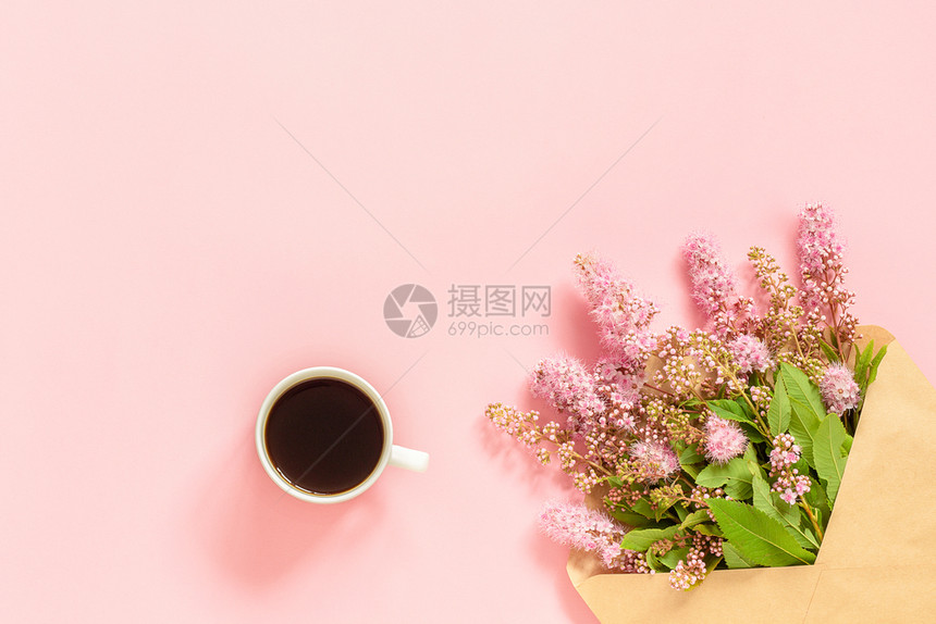 开花信封中的粉红色花束背景上的咖啡杯贺卡平躺复制空间概念早上好或Womenrsquos日信封中的粉红色花束一杯咖啡和张白色空卡用图片