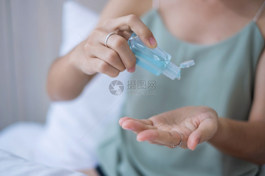 疾病医院抗菌在家醒来时床上用酒精凝胶清洁剂洗手的妇女保护冠状Covid19感染Covid19感染生活方式新正常和个人卫生概念图片