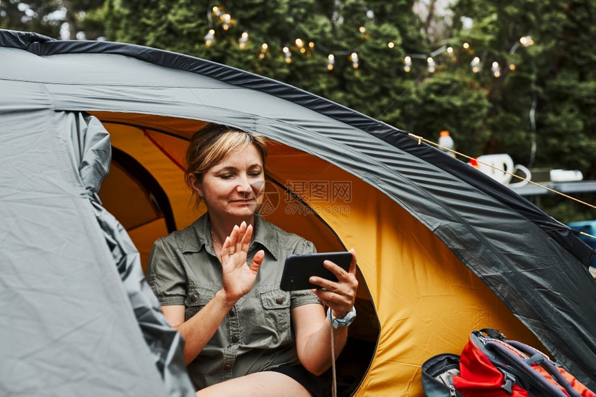 女在暑假期间坐露营妇女帐篷的里放松在中休息与自然质相近的户外度假营地生活概念跃地在野外渡假游客冒险坐着图片