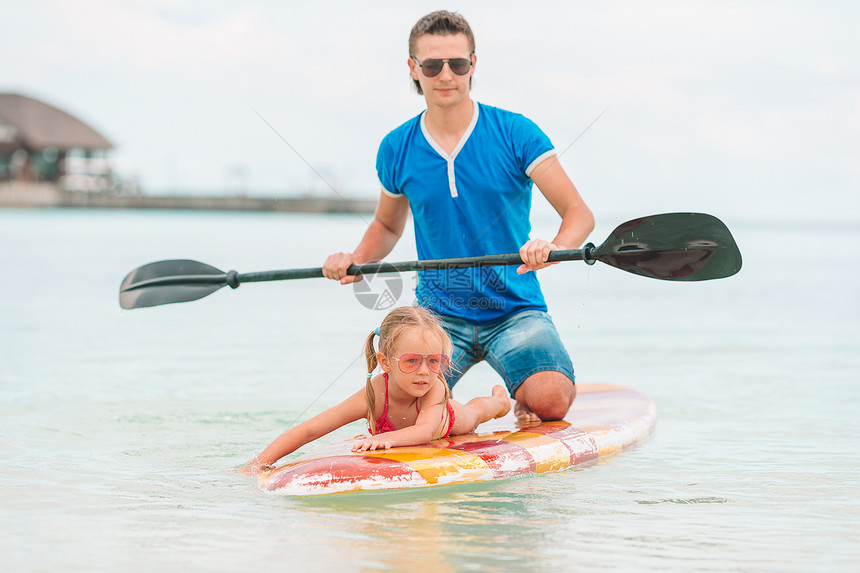 孩子们爸和小女儿的家庭快乐地一起在大海划船暑假期间爸和孩子在冲浪板上玩耍的家年轻海洋图片