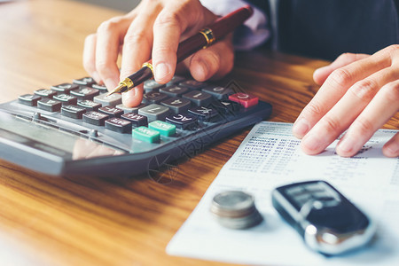 信用数商业家手握办公室计算器和成本财务数据分析计在木制办公桌上钱图片