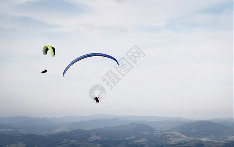 空气多于运动两架滑翔的机在云天背景下飞越山上图片