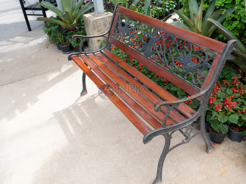 长椅有条纹的在植物园混凝土通道附近带金属板架的木制凳自然图片