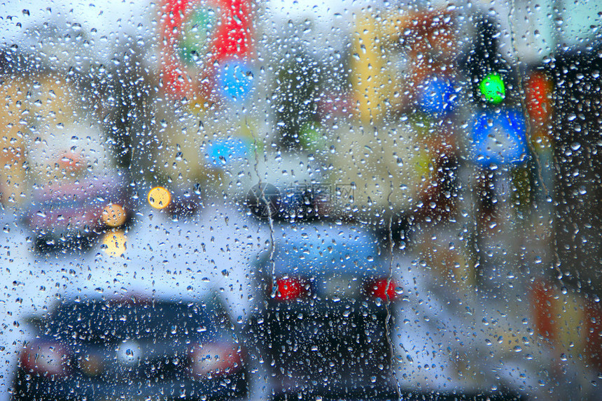 丰富多彩的城市灯光背景下的窗外雨时滴在玻璃上的水下雨时窗玻璃外的水滴城市下雨灯光背景下的窗外雨时玻璃上的水滴质地移动