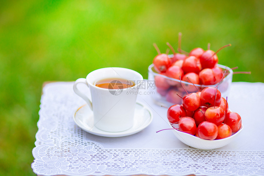 树叶健康输液早上在花园里喝一杯带天堂苹果的白热茶自然背景模糊早上好在花园里喝一杯带天堂苹果的白热茶自然背景模糊图片
