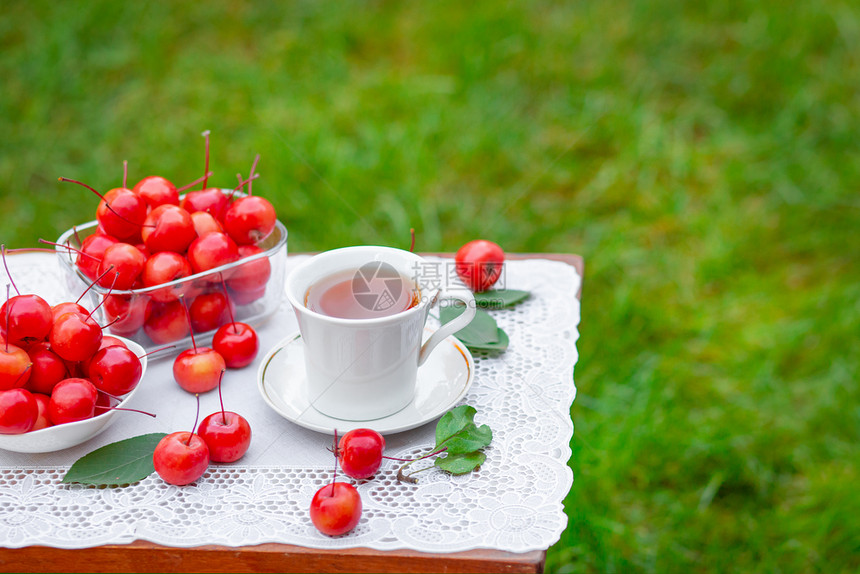 早餐输液上在花园里喝一杯带天堂苹果的白热茶自然背景模糊早上好在花园里喝一杯带天堂苹果的白热茶自然背景模糊好的图片