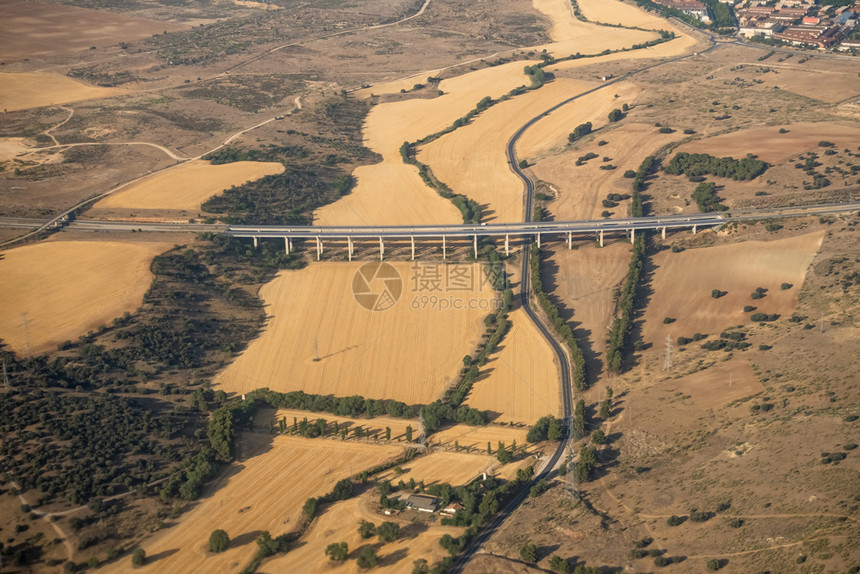 踪迹在大都市区以外的马德里域空中观察飞越农田和西班牙公路上空飞行越农业田间和马路环境追踪图片