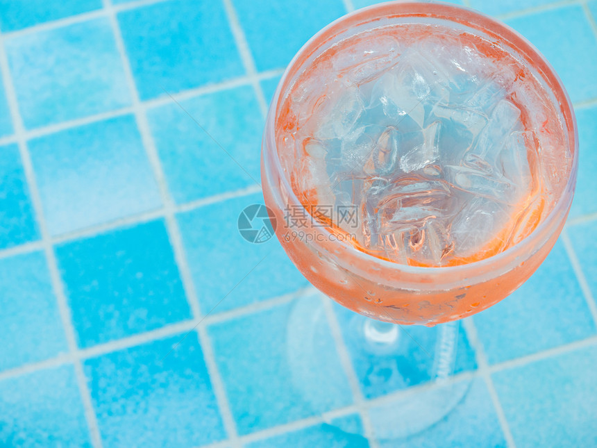 香槟酒美丽的玻璃和粉红鸡尾酒及冰立方体在泳池的底座上蓝色水面观光在海上巡洋时特勤休息漂亮的玻璃和粉红色鸡尾酒及冰立方体甲板酒吧图片