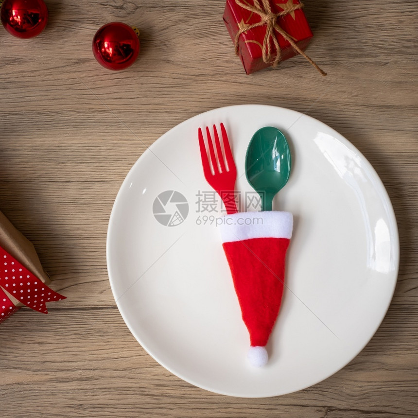 圣诞快乐车牌叉子和勺放在木桌背景Xmas派对和新年快乐概念木制的桌子帽图片