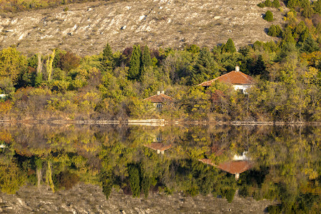 在湖水景观中反射的湖泊森林和房屋图片