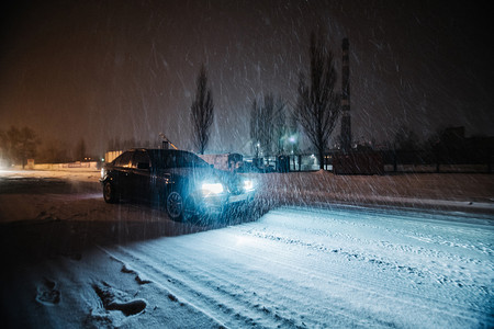 风暴晚上开车在雪地路外面下了很多雪雾路段自然城市的高清图片素材