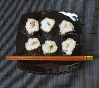 一个黑盘子有寿司和鲑鱼厨房东美食图片