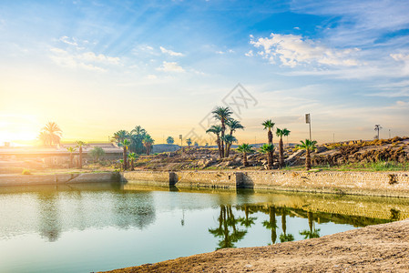在卡纳克寺的圣湖卡纳克寺的卢索神圣湖上空日出柱子埃及建造图片